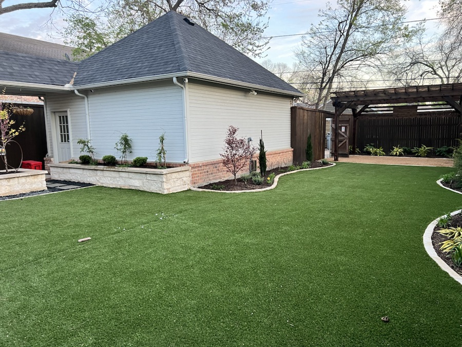Completed AJS Elite outdoor living project with lawn, planting beds, and pergola